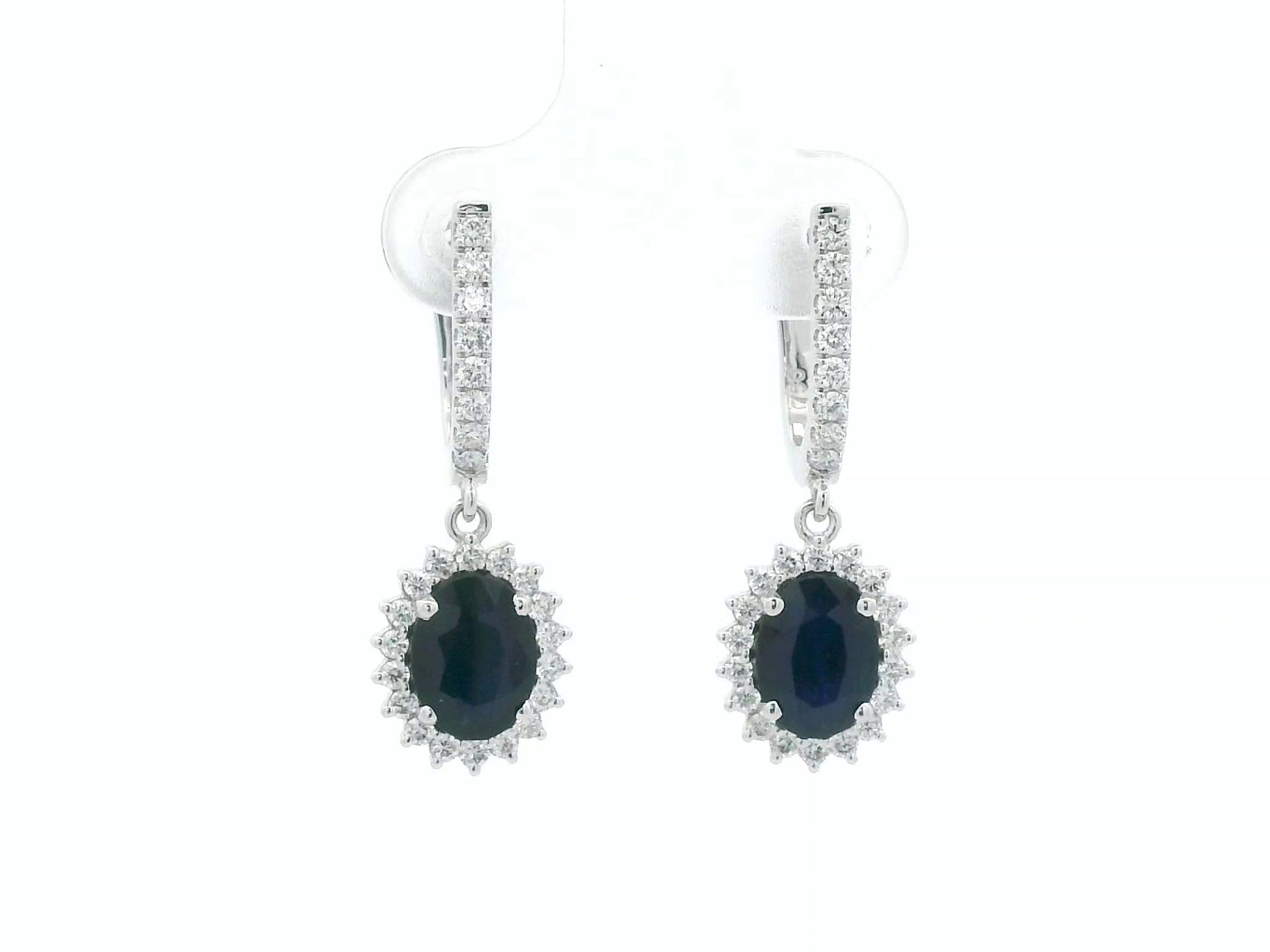 18K white gold sapphire and diamond drop earrings with oval sapphire halos by Emirates Diamonds