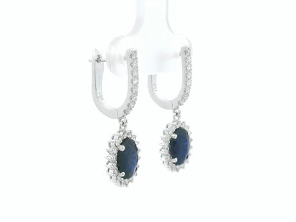18K white gold sapphire and diamond drop earrings with oval sapphire halos by Emirates Diamonds