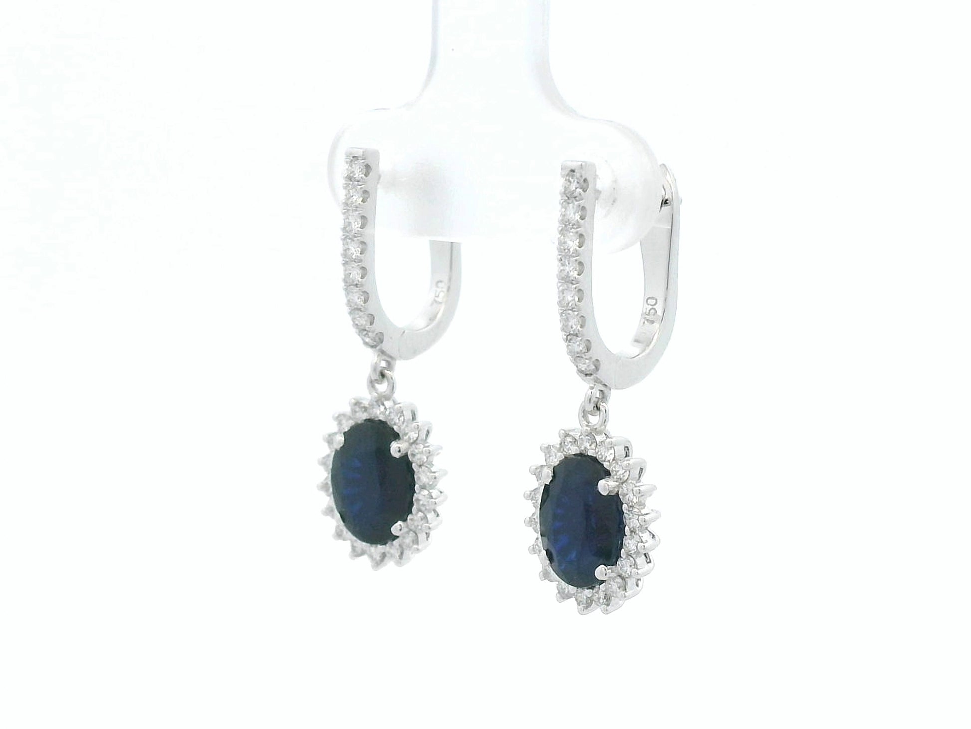 18K white gold sapphire and diamond drop earrings with oval sapphire halos by Emirates Diamonds
