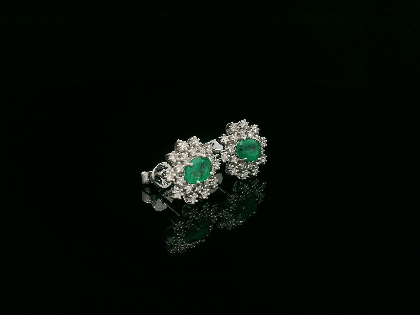 18K white gold emerald and diamond stud earrings with oval emerald center by Emirates Diamonds