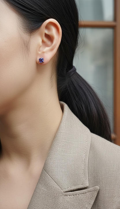 Square emerald-cut tanzanite solitaire stud earrings in 18K white gold by Emirates Diamonds.