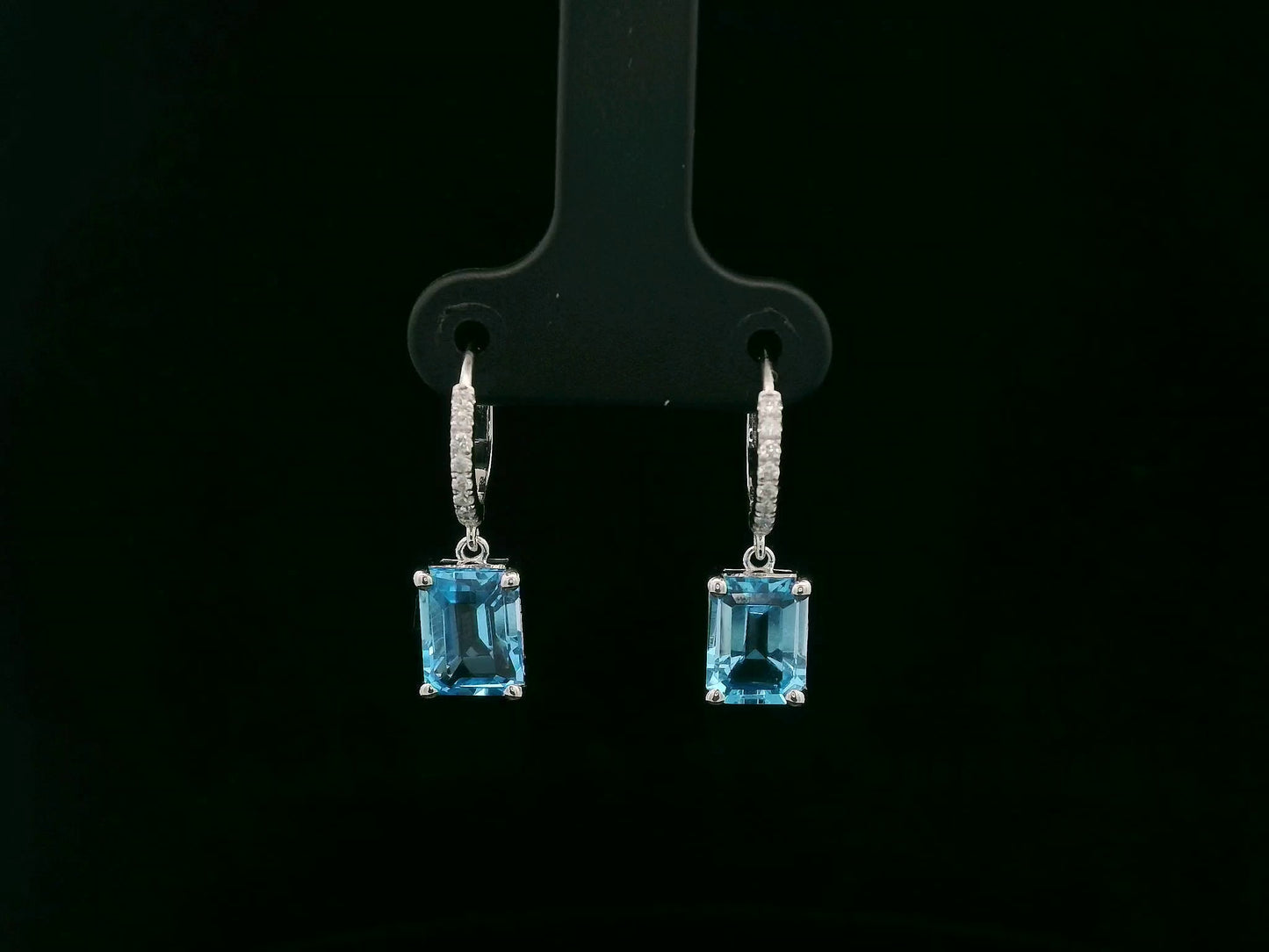 18K white gold hoop drop earrings featuring emerald-cut Swiss Blue Topaz and diamond accents by Emirates Diamonds.