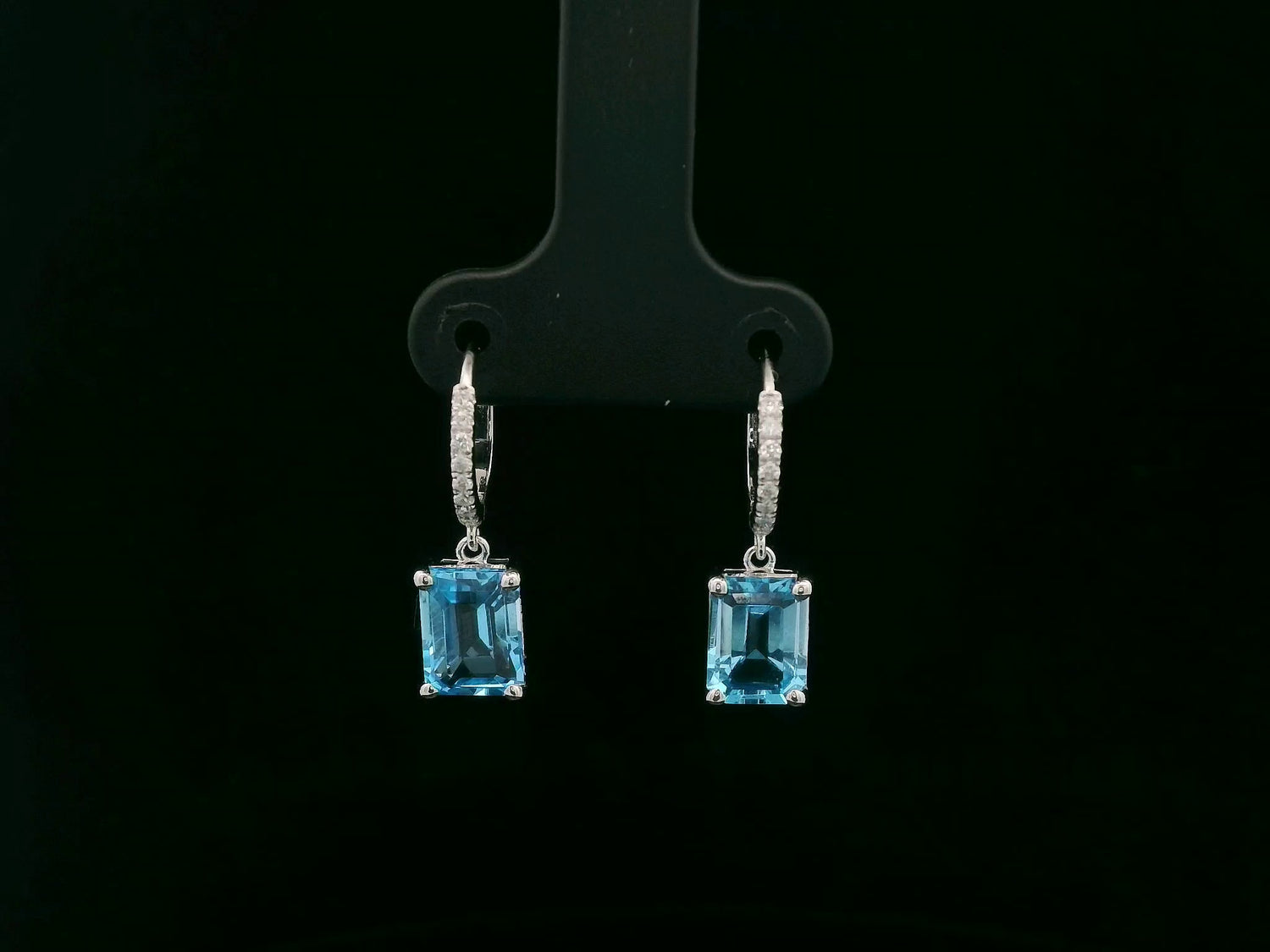 18K white gold hoop drop earrings featuring emerald-cut Swiss Blue Topaz and diamond accents by Emirates Diamonds.