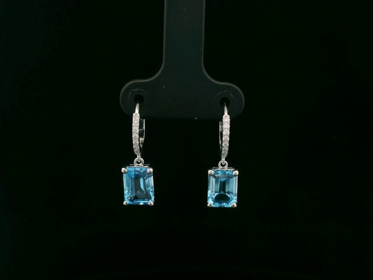 18K white gold hoop drop earrings featuring emerald-cut Swiss Blue Topaz and diamond accents by Emirates Diamonds.
