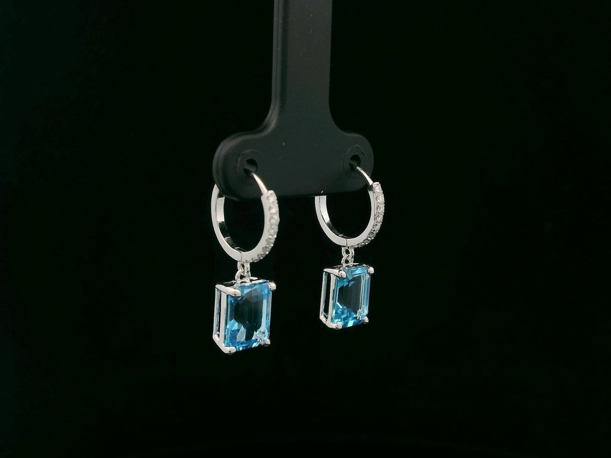 18K white gold hoop drop earrings featuring emerald-cut Swiss Blue Topaz and diamond accents by Emirates Diamonds.