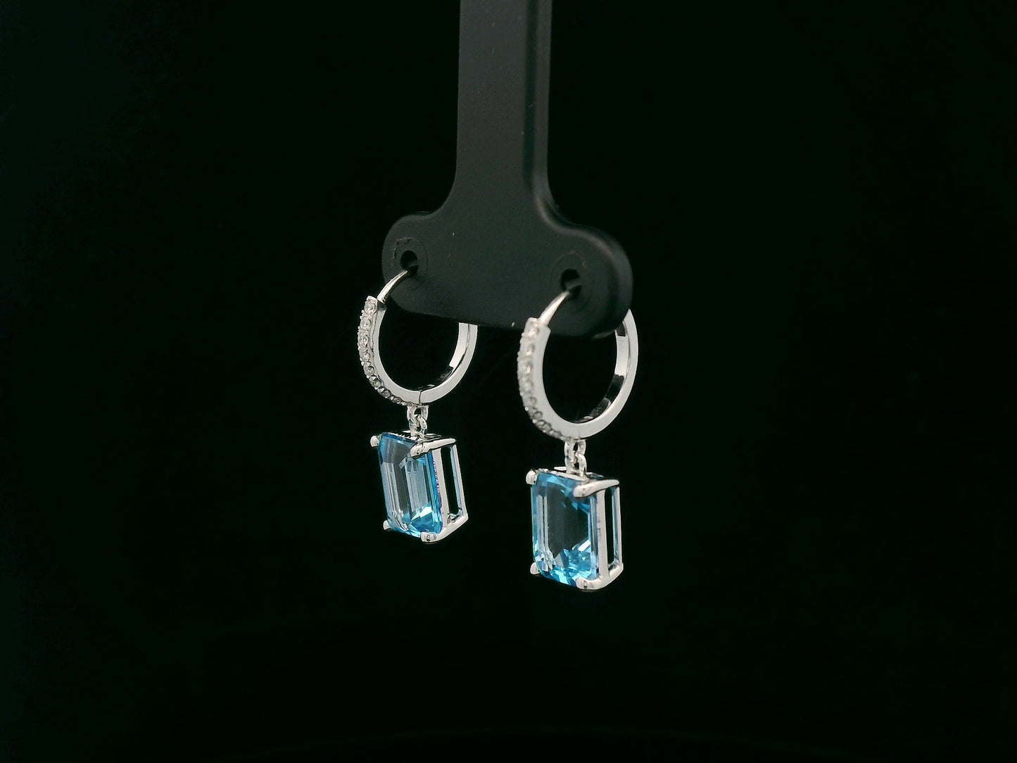 18K white gold hoop drop earrings featuring emerald-cut Swiss Blue Topaz and diamond accents by Emirates Diamonds.