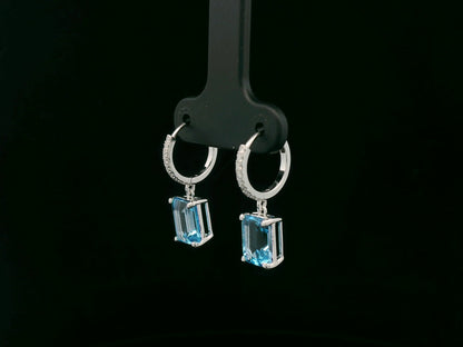 18K white gold hoop drop earrings featuring emerald-cut Swiss Blue Topaz and diamond accents by Emirates Diamonds.