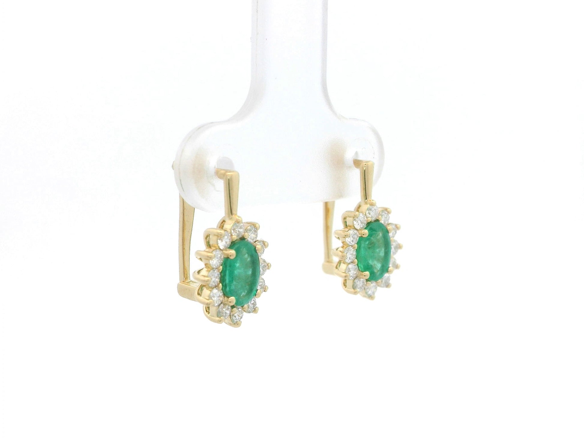 18K yellow gold emerald and diamond halo earrings featuring oval-cut emeralds surrounded by brilliant diamonds by Emirates Diamonds.