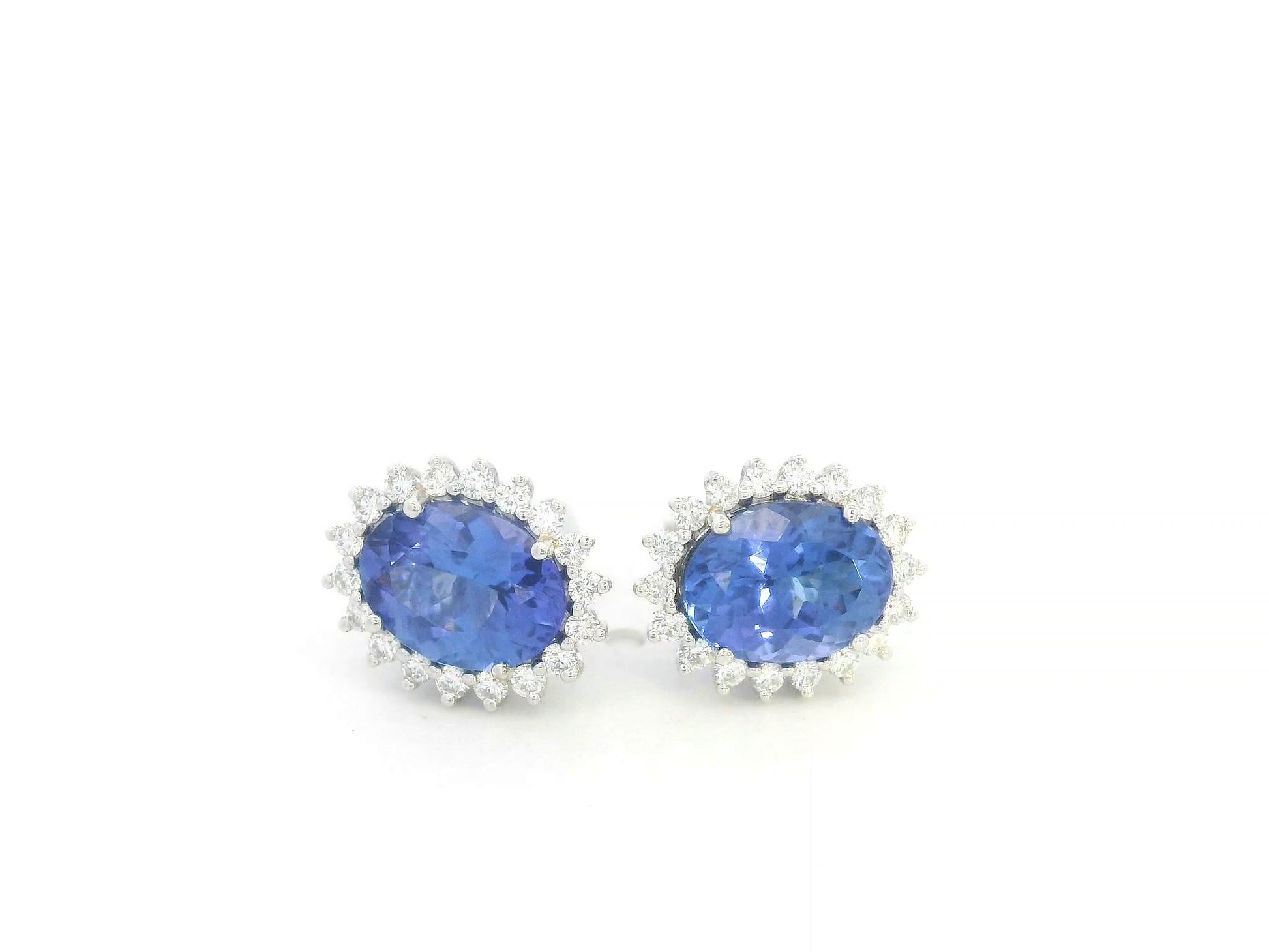 18K white gold earrings featuring oval-cut tanzanite gemstones surrounded by diamond halos by Emirates Diamonds.