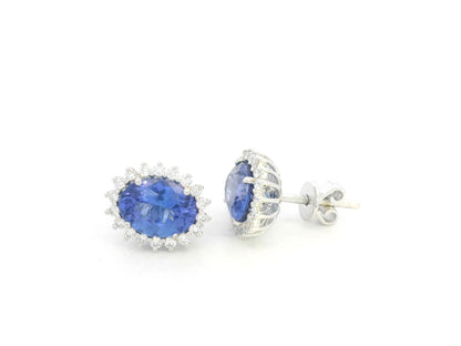 18K white gold earrings featuring oval-cut tanzanite gemstones surrounded by diamond halos by Emirates Diamonds.