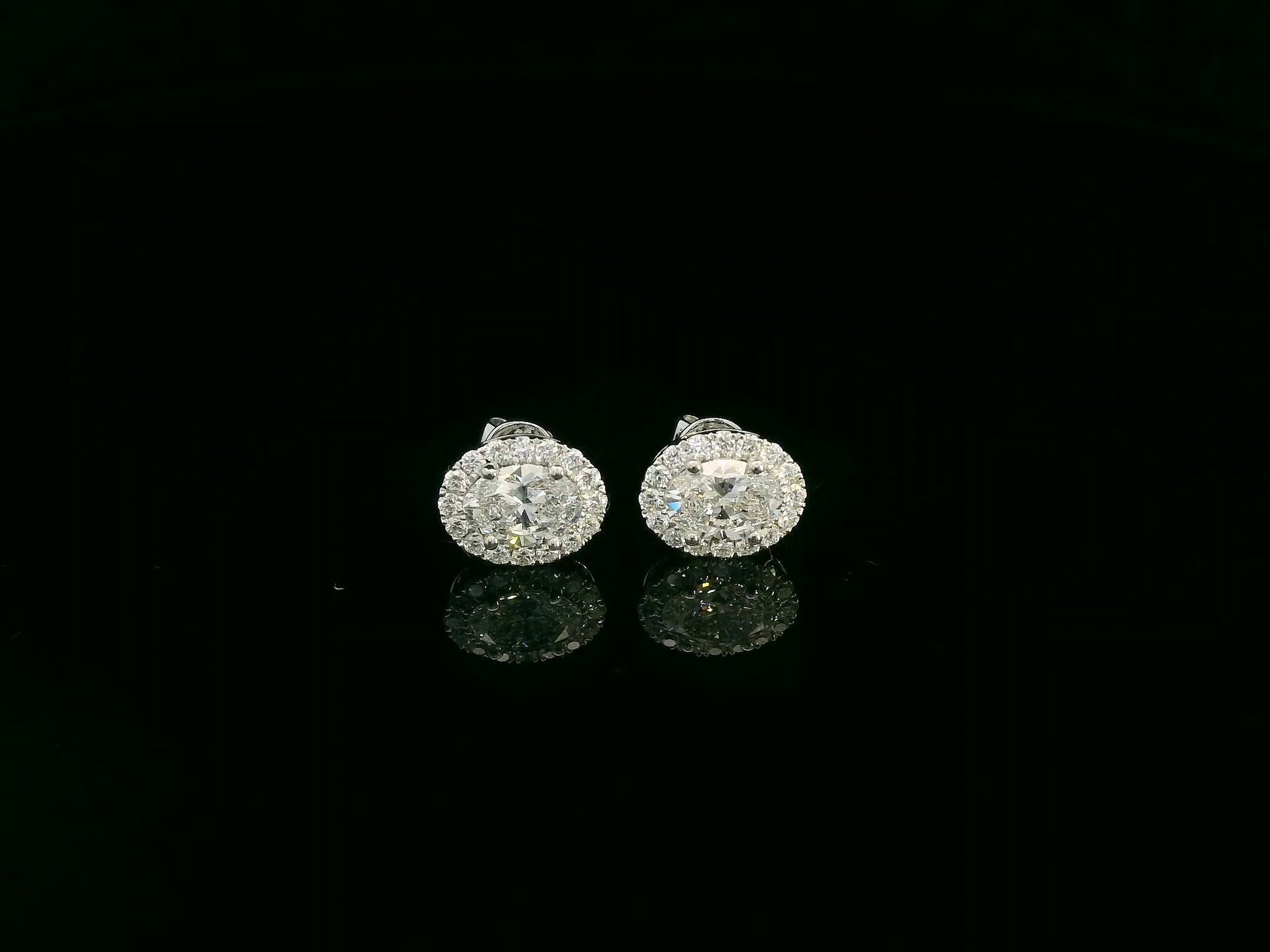 18K white gold oval cut diamond halo stud earrings with 1.40 carat GIA certified diamonds by Emirates Diamonds
