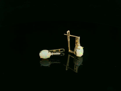 Oval opal and diamond drop earrings in 18K yellow gold by Emirates Diamonds.