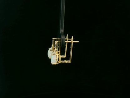 Oval opal and diamond drop earrings in 18K yellow gold by Emirates Diamonds.