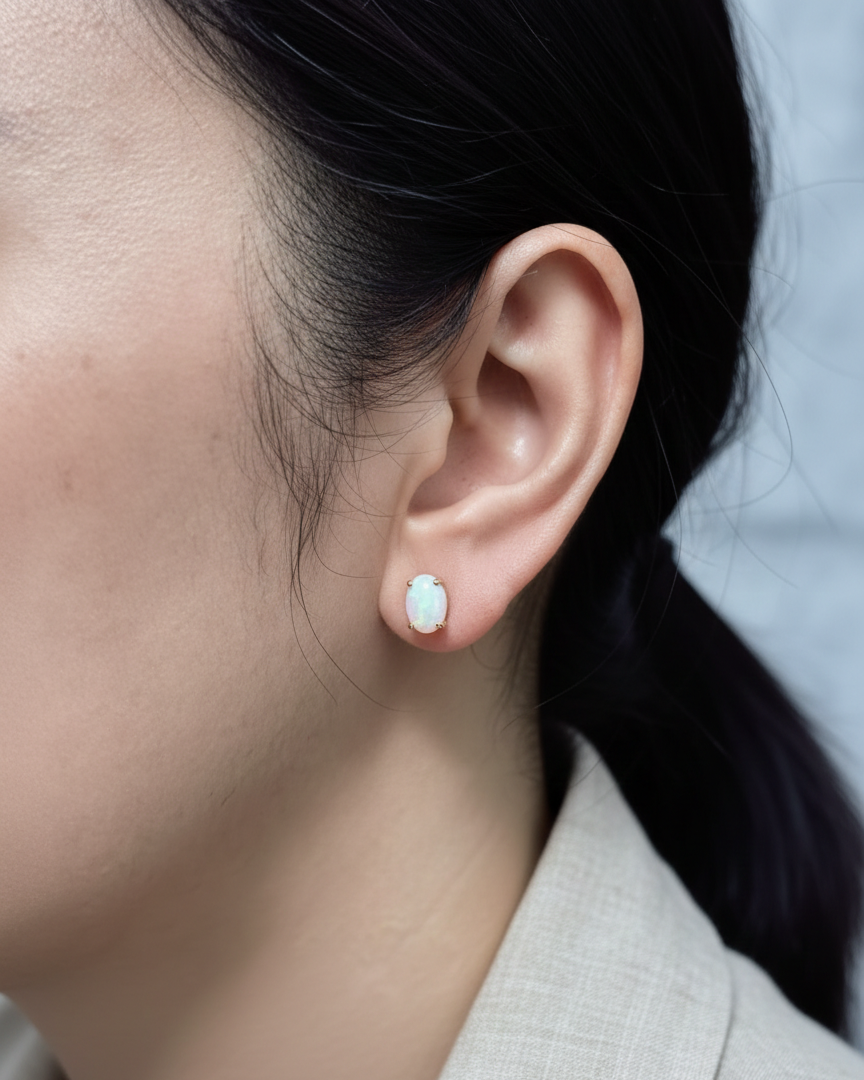 18K yellow gold opal stud earrings featuring 1.63 carat oval opals with classic prong setting by Emirates Diamonds.