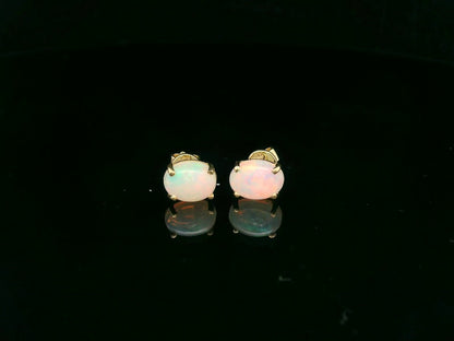 18K yellow gold opal stud earrings featuring 1.63 carat oval opals with classic prong setting by Emirates Diamonds.
