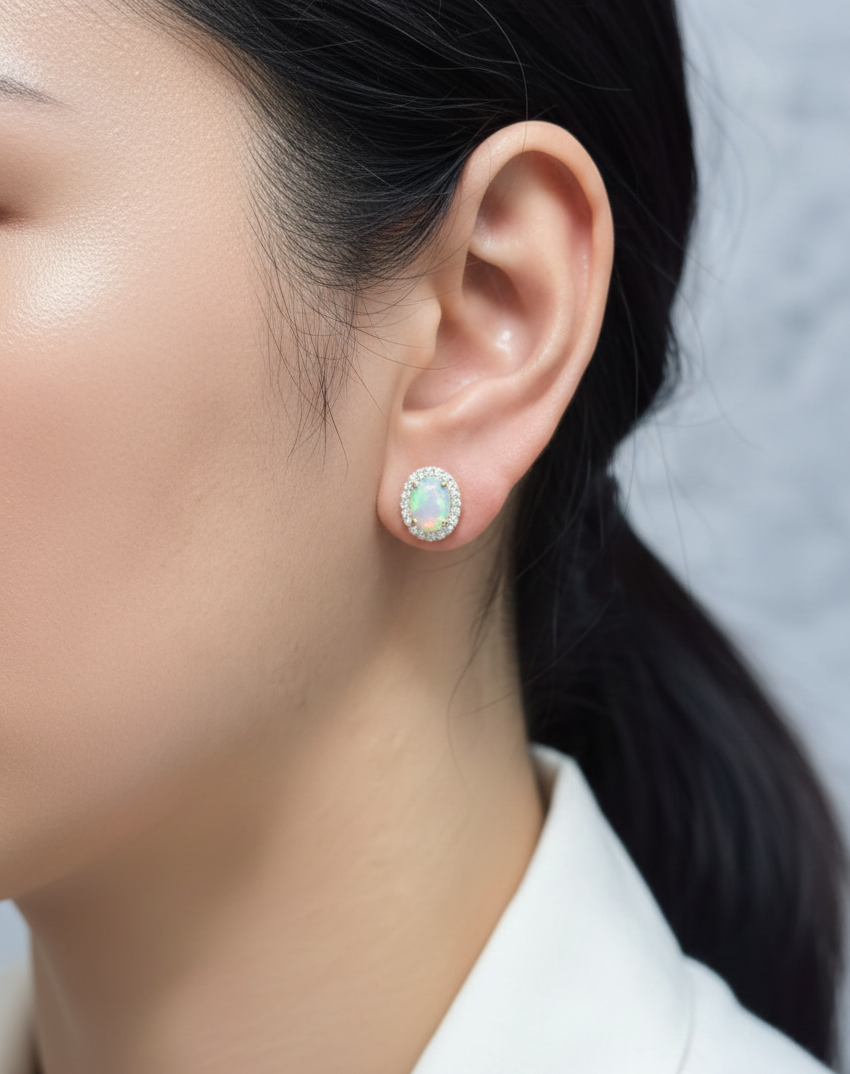 Oval opal and diamond halo stud earrings in 18K yellow gold by Emirates Diamonds.