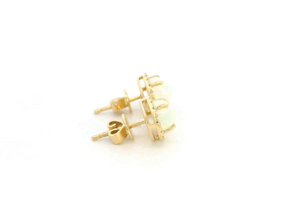 Oval opal and diamond halo stud earrings in 18K yellow gold by Emirates Diamonds.