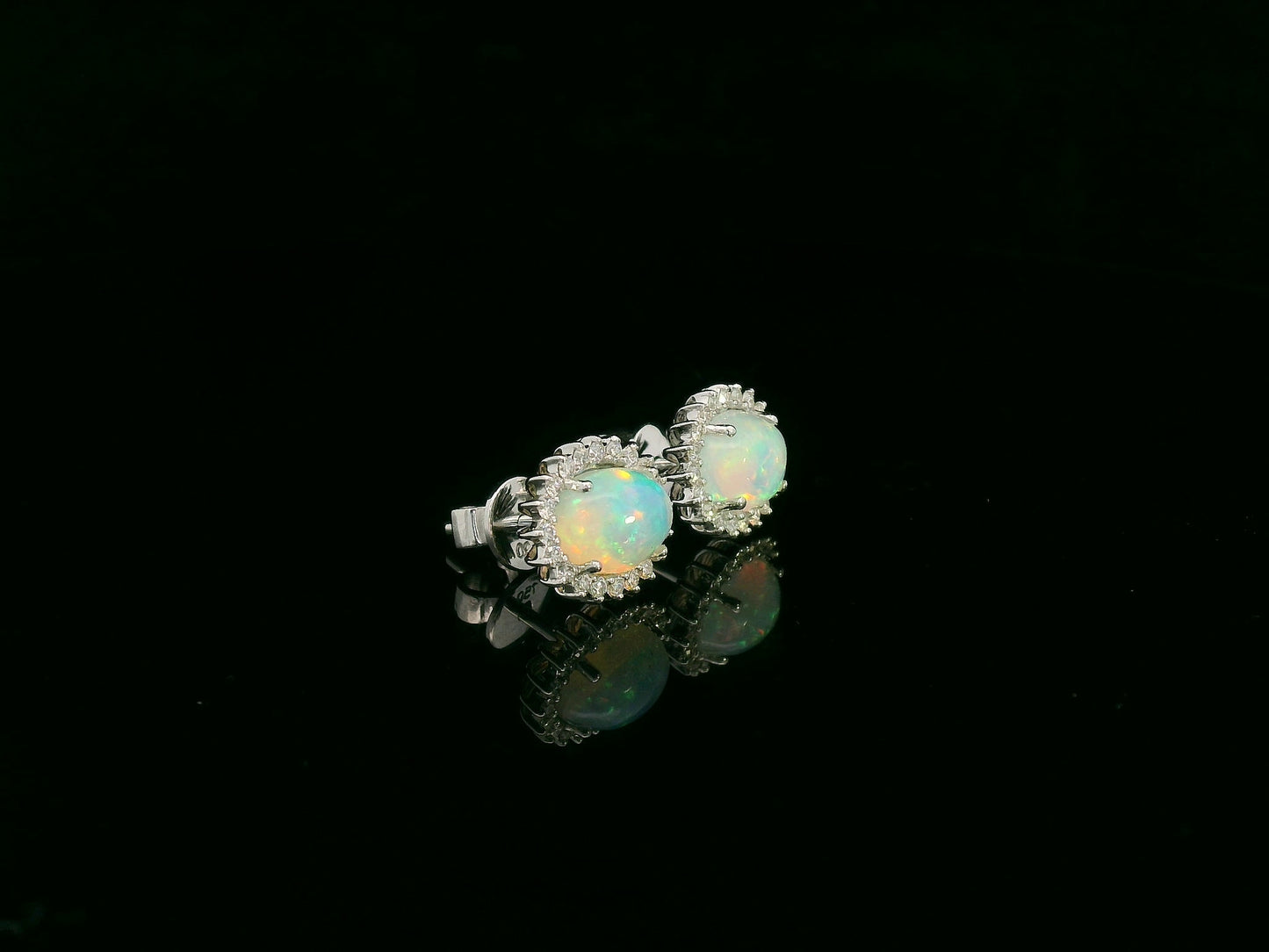 Opal and diamond halo stud earrings in 18K white gold by Emirates Diamonds.