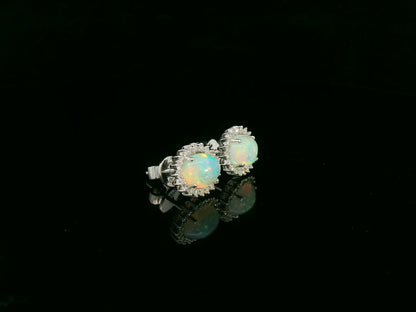 Opal and diamond halo stud earrings in 18K white gold by Emirates Diamonds.