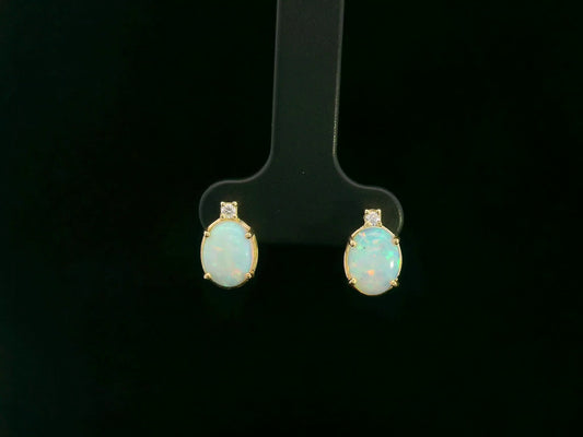 18K yellow gold opal and diamond stud earrings with oval opals and subtle diamond accents, luxury fine jewelry by Emirates Diamonds.