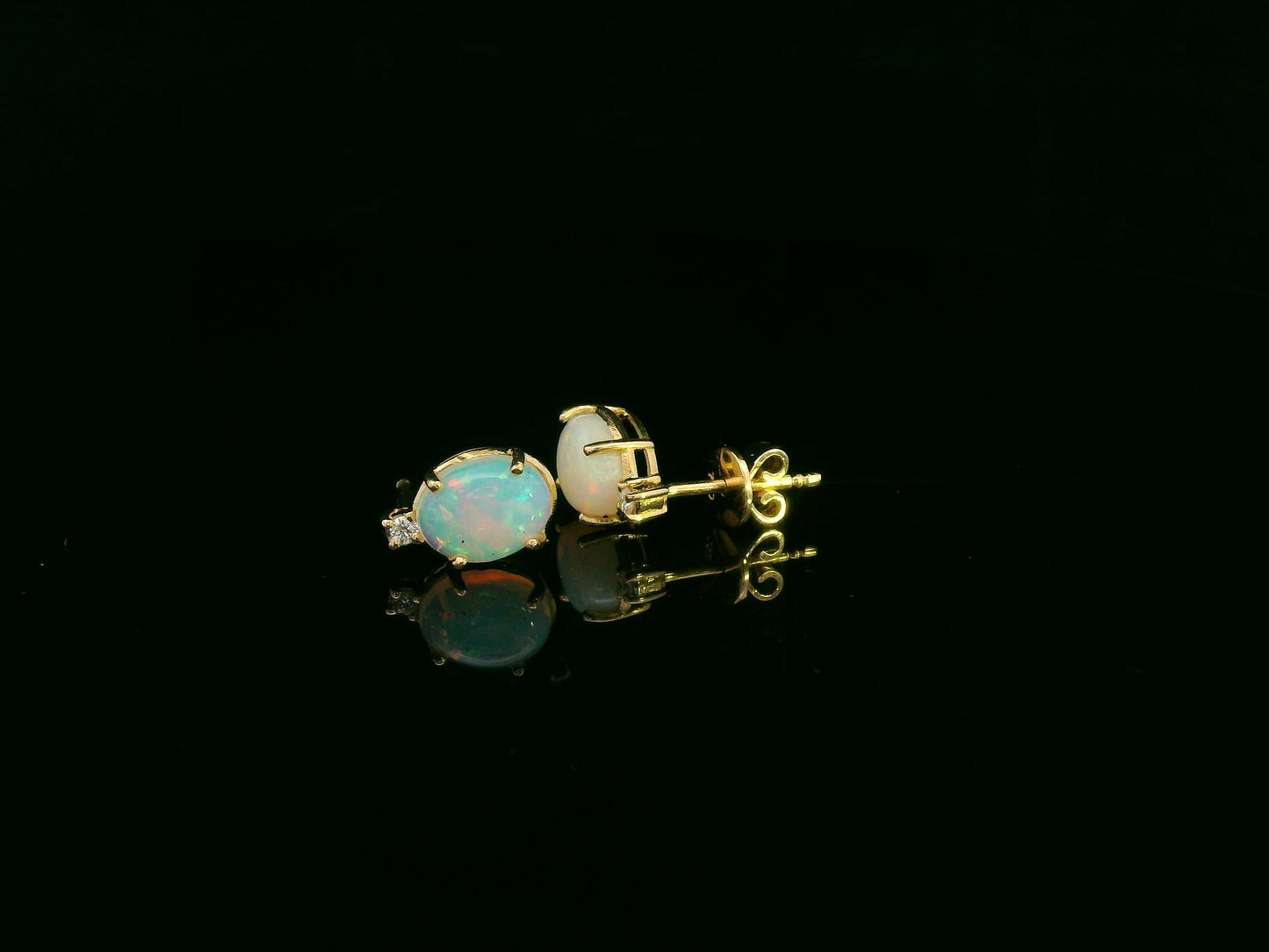 18K yellow gold opal and diamond stud earrings with oval opals and subtle diamond accents, luxury fine jewelry by Emirates Diamonds.