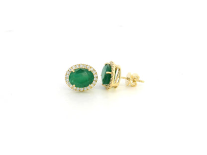 18K yellow gold emerald and diamond halo stud earrings with oval emeralds and brilliant diamond accents by Emirates Diamonds.