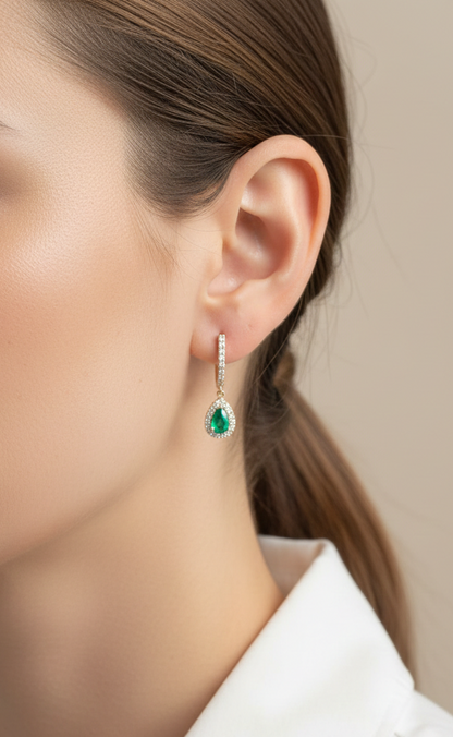 18K yellow gold emerald and diamond drop earrings with pear-shaped emeralds and diamond halo, luxury fine jewelry by Emirates Diamonds.