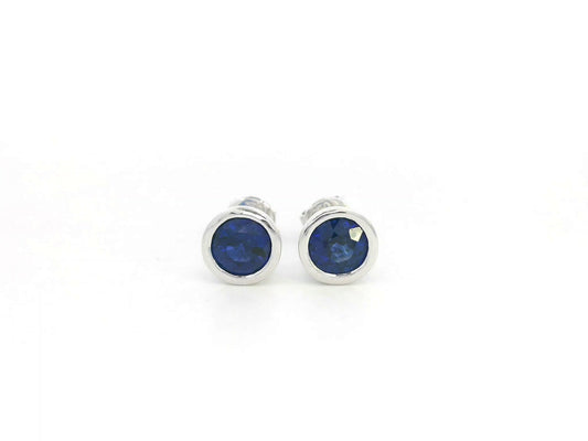 18K white gold bezel-set blue sapphire stud earrings with round cut sapphires, total sapphire weight 1.44 carat, Emirates Diamonds.