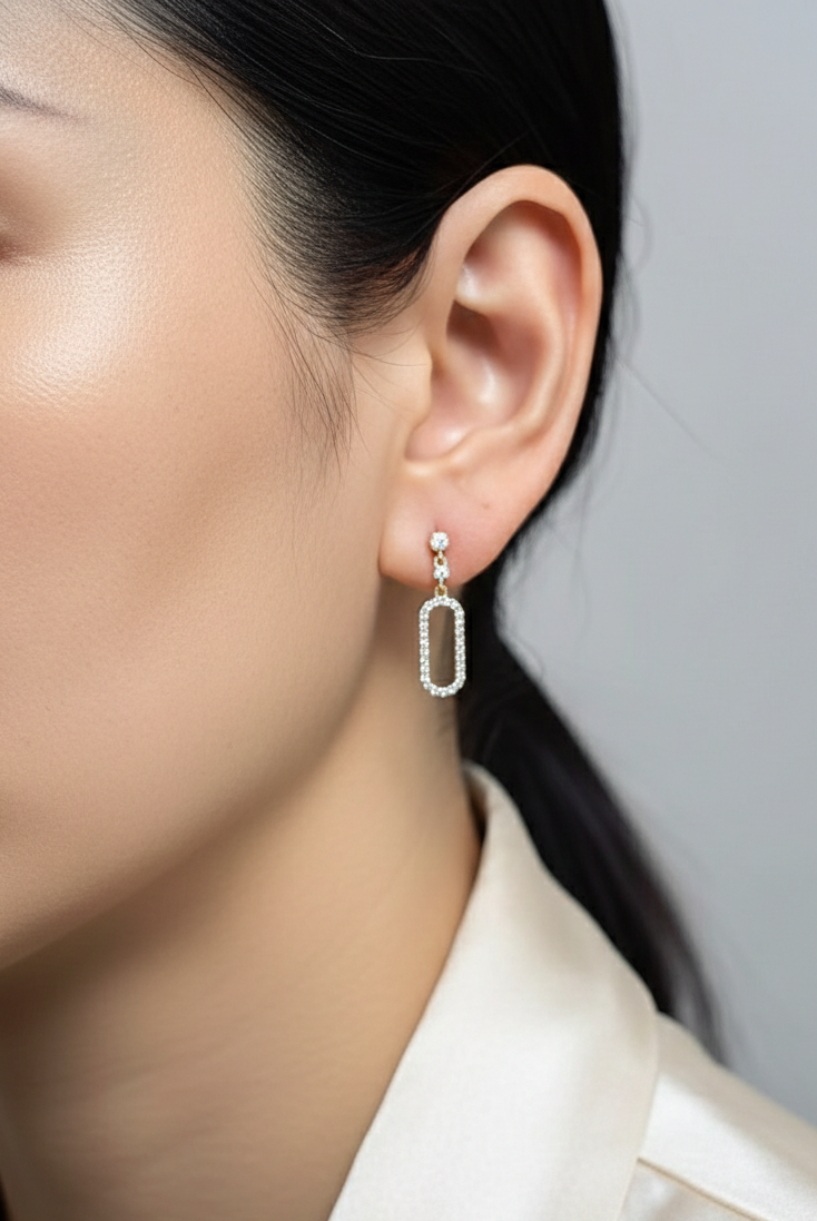 18K yellow gold diamond drop earrings featuring an elongated pavé-set oval design by Emirates Diamonds.
