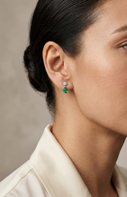 Pear-shaped emerald and diamond drop earrings in 18K yellow gold featuring 0.76 carat emeralds and 0.06 carat diamonds by Emirates Diamonds.