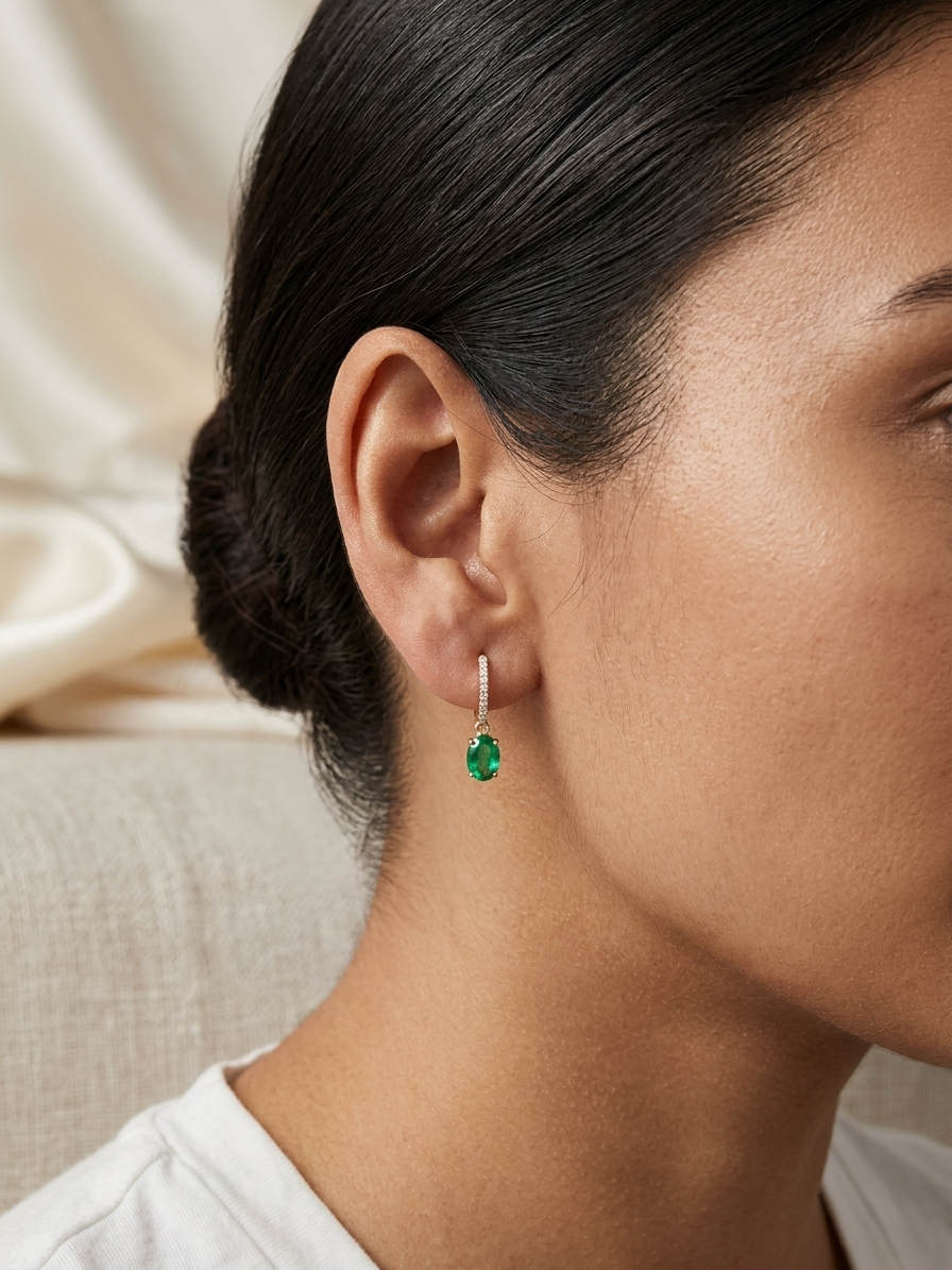 Emerald drop hoop earrings in 18K yellow gold with 0.95 carat emeralds and 0.09 carat diamond pavé hoops by Emirates Diamonds.
