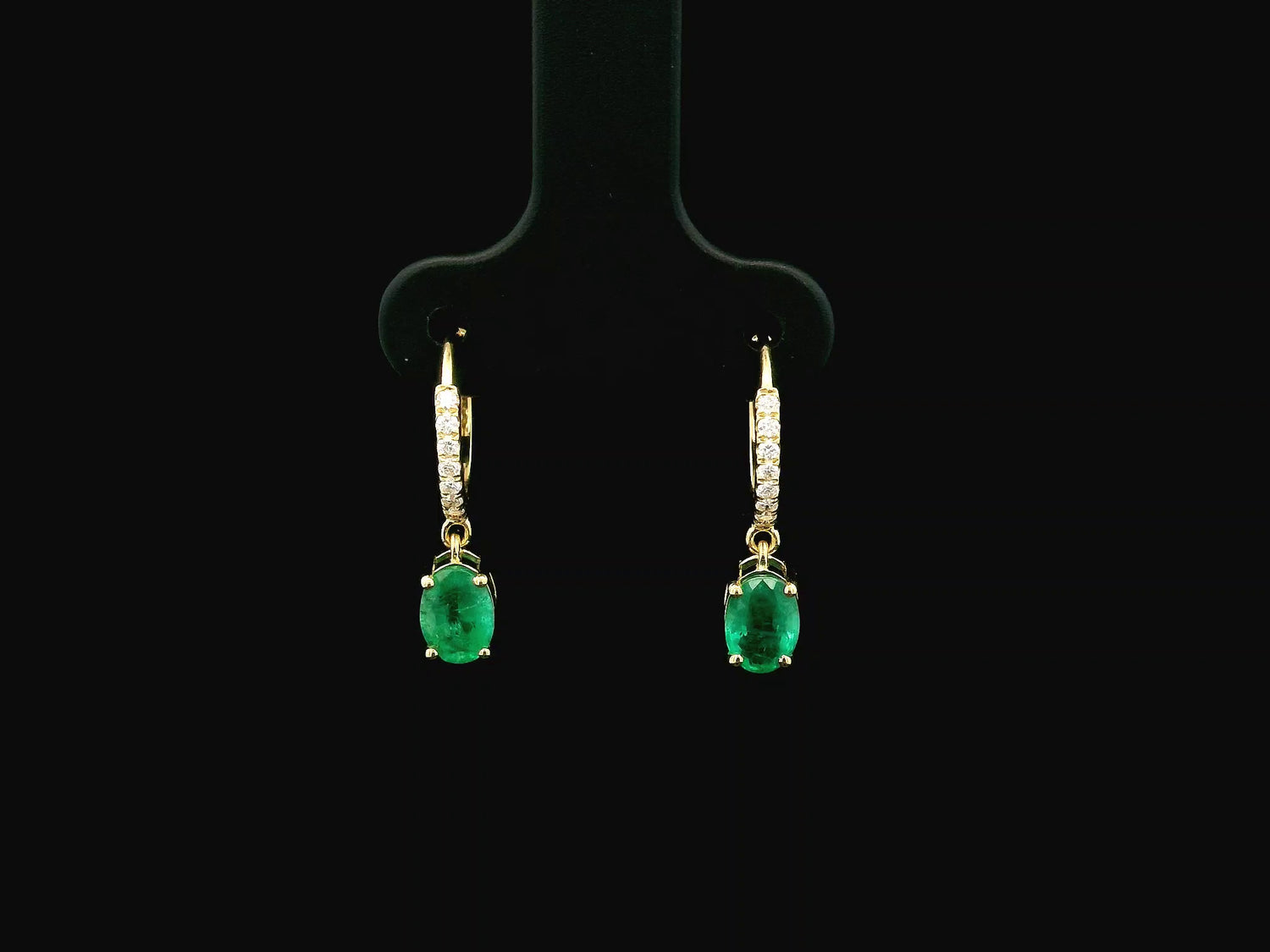 Emerald drop hoop earrings in 18K yellow gold with 0.95 carat emeralds and 0.09 carat diamond pavé hoops by Emirates Diamonds.