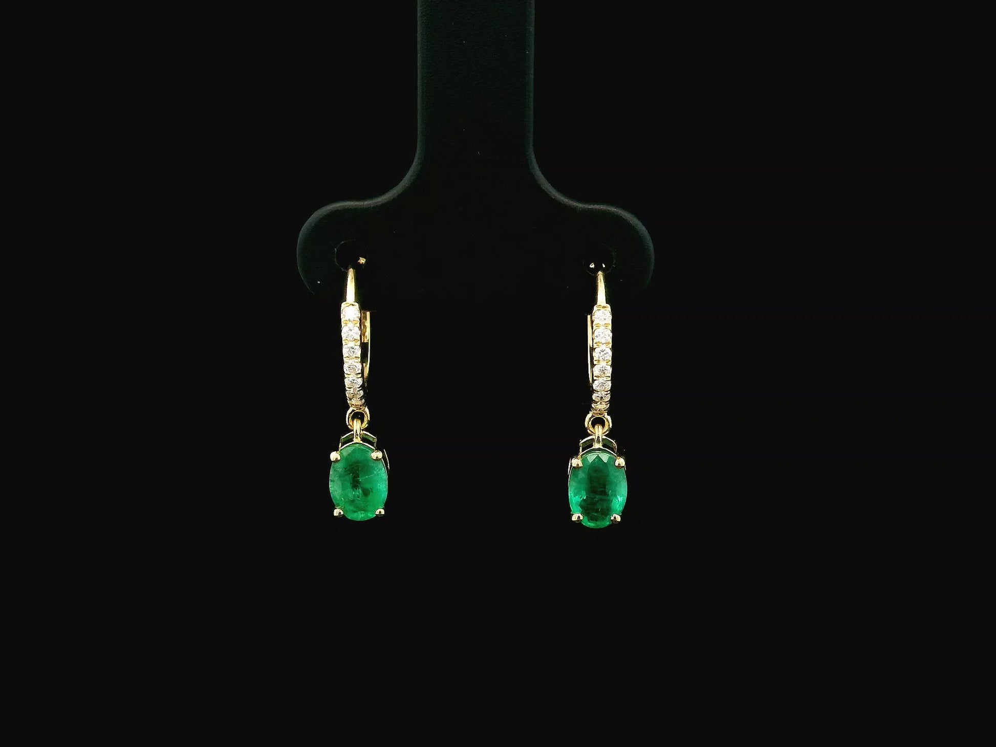 Emerald drop hoop earrings in 18K yellow gold with 0.95 carat emeralds and 0.09 carat diamond pavé hoops by Emirates Diamonds.