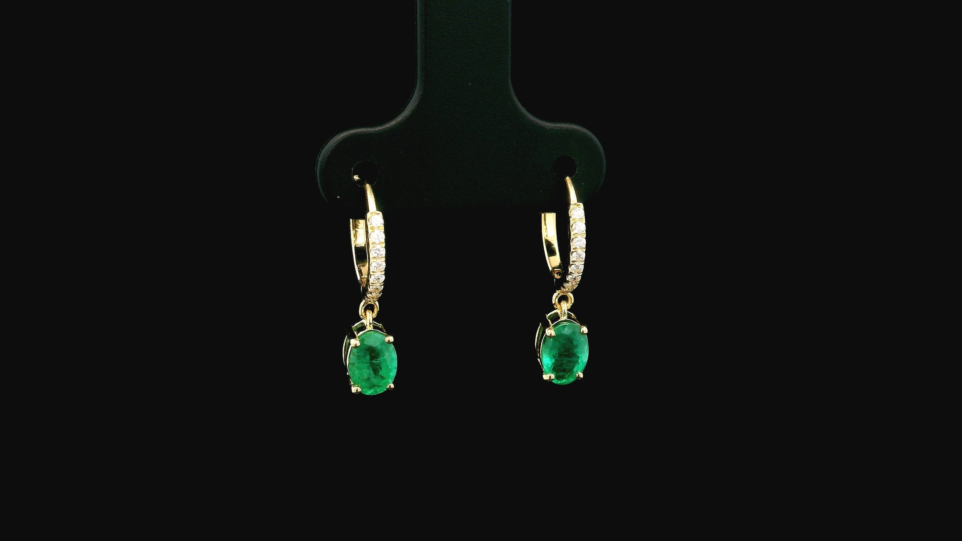 Emerald drop hoop earrings in 18K yellow gold with 0.95 carat emeralds and 0.09 carat diamond pavé hoops by Emirates Diamonds.