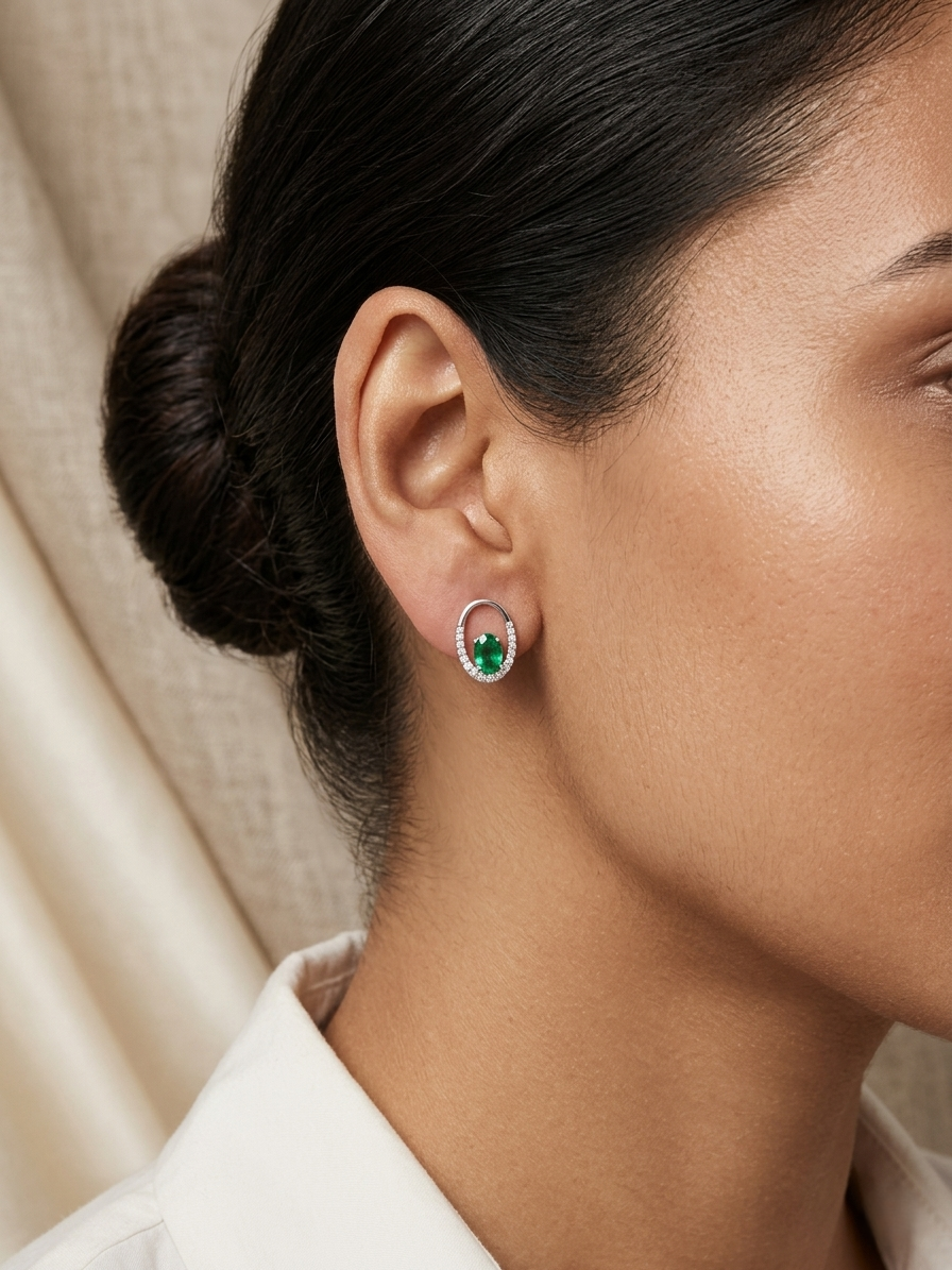 Emerald and diamond halo stud earrings in 18K white gold featuring 0.92 carat emeralds and 0.20 carat diamonds by Emirates Diamonds.