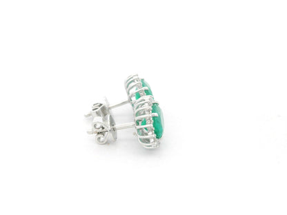 Emerald and diamond halo stud earrings in 18K white gold featuring 2.31 carat emeralds and 0.36 carat diamonds by Emirates Diamonds.
