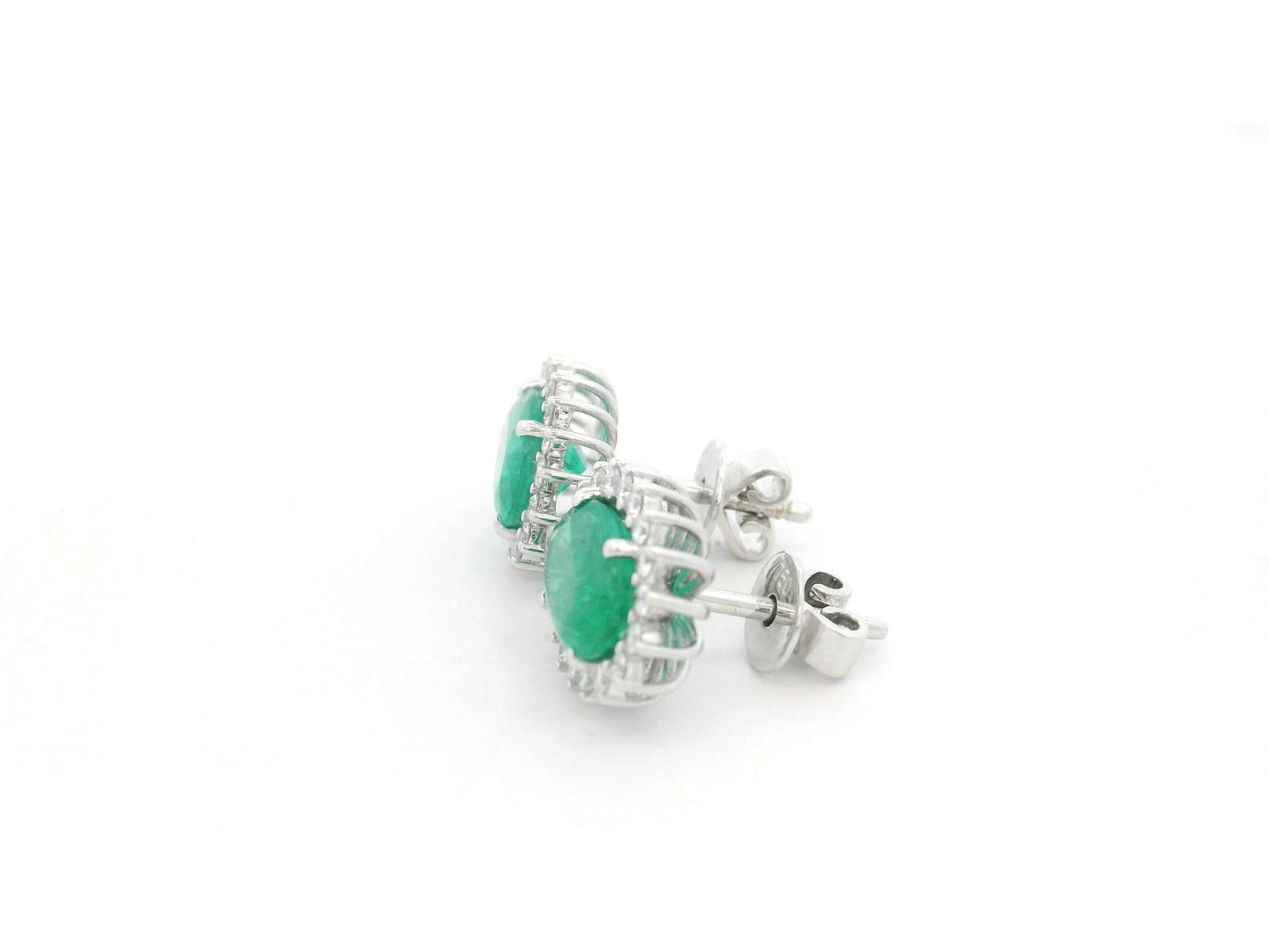 Emerald and diamond halo stud earrings in 18K white gold featuring 2.31 carat emeralds and 0.36 carat diamonds by Emirates Diamonds.