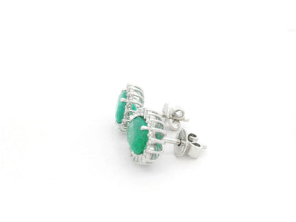 Emerald and diamond halo stud earrings in 18K white gold featuring 2.31 carat emeralds and 0.36 carat diamonds by Emirates Diamonds.