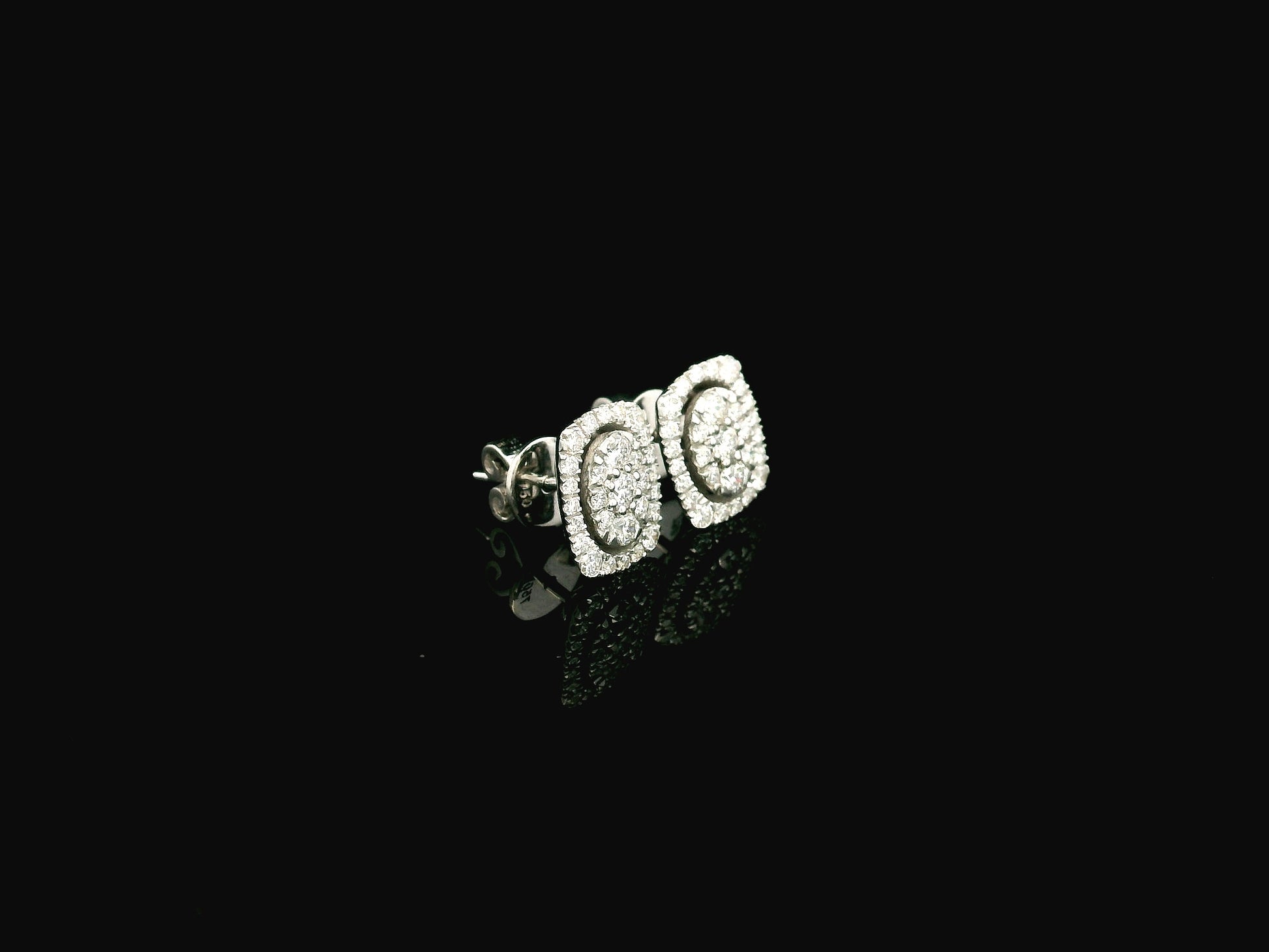 18K white gold diamond halo stud earrings featuring round brilliant diamonds with cushion halo design and 0.64 carat total diamond weight