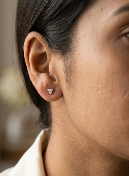 18K white gold diamond stud earrings featuring a delicate three-diamond design with a total diamond weight of 0.20 carat.