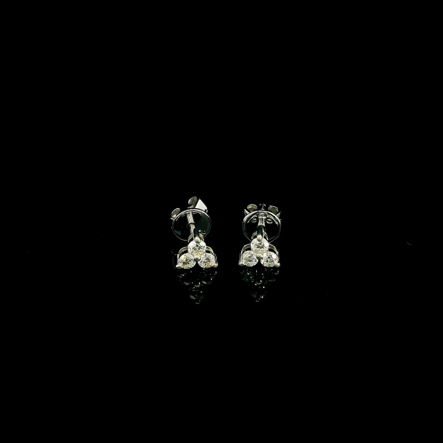 18K white gold diamond stud earrings featuring a delicate three-diamond design with a total diamond weight of 0.20 carat.