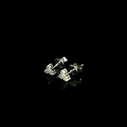18K white gold diamond stud earrings featuring a delicate three-diamond design with a total diamond weight of 0.20 carat.
