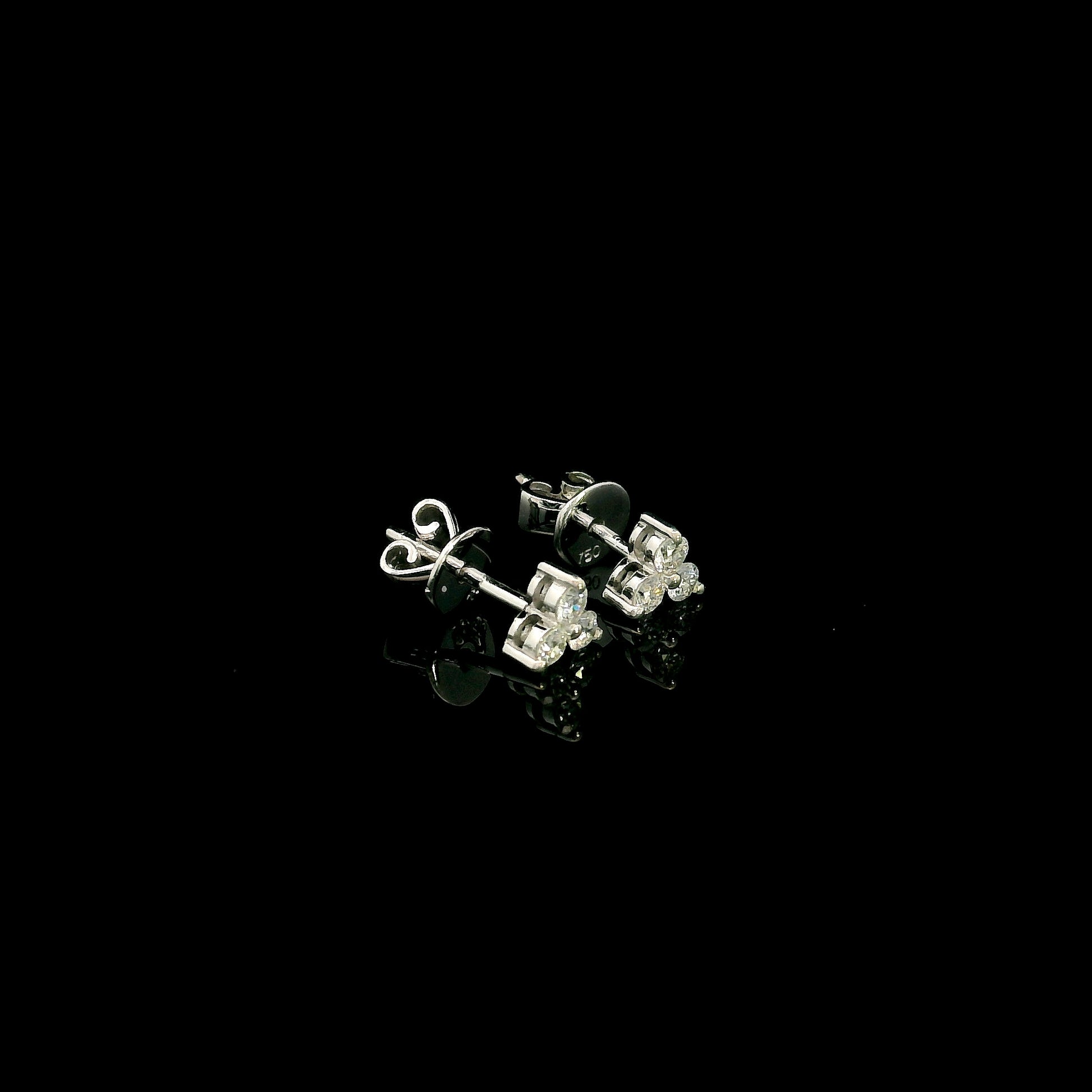 18K white gold diamond stud earrings featuring a delicate three-diamond design with a total diamond weight of 0.20 carat.