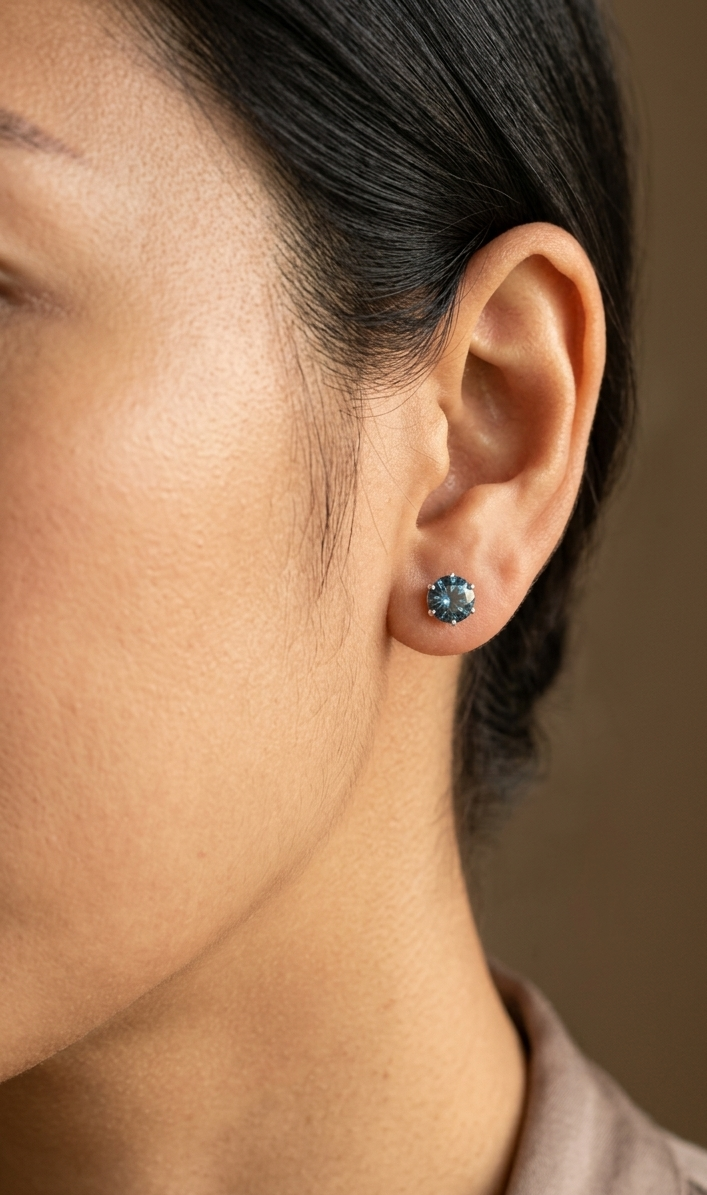 London Blue Topaz solitaire stud earrings in 18K white gold featuring 1.90 carats of natural round London Blue Topaz.
