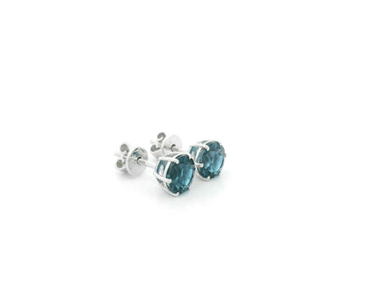 London Blue Topaz solitaire stud earrings in 18K white gold featuring 1.90 carats of natural round London Blue Topaz.