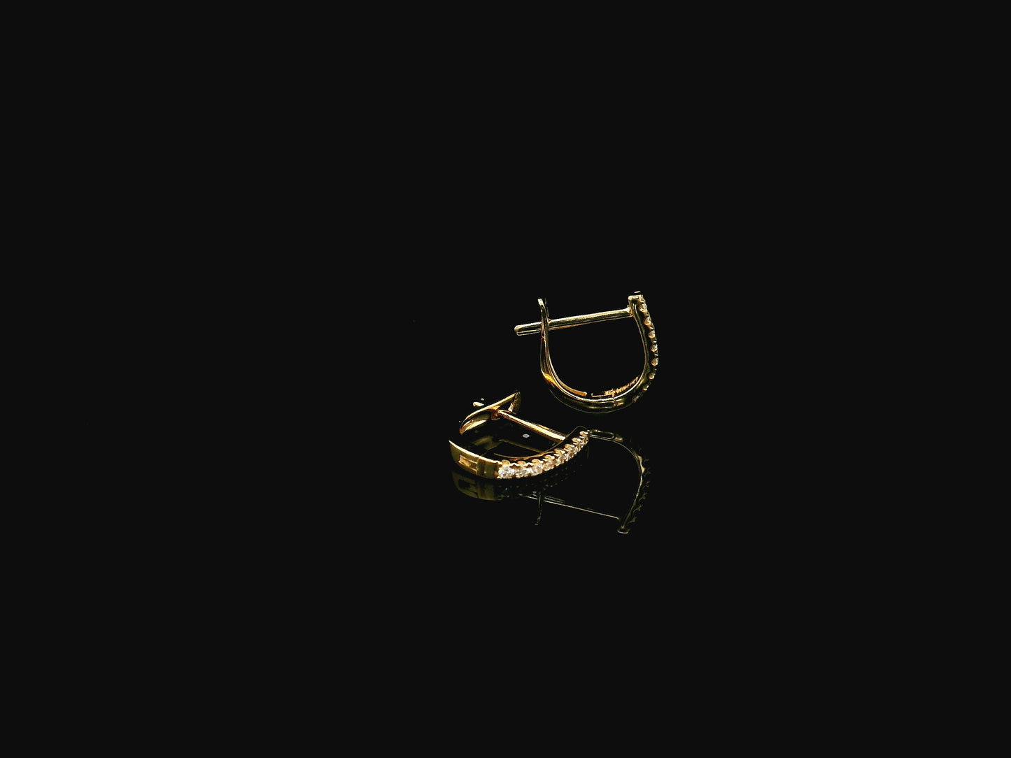 18K yellow gold diamond huggie hoop earrings featuring 0.09 carats of natural diamonds in a classic everyday hoop design.
