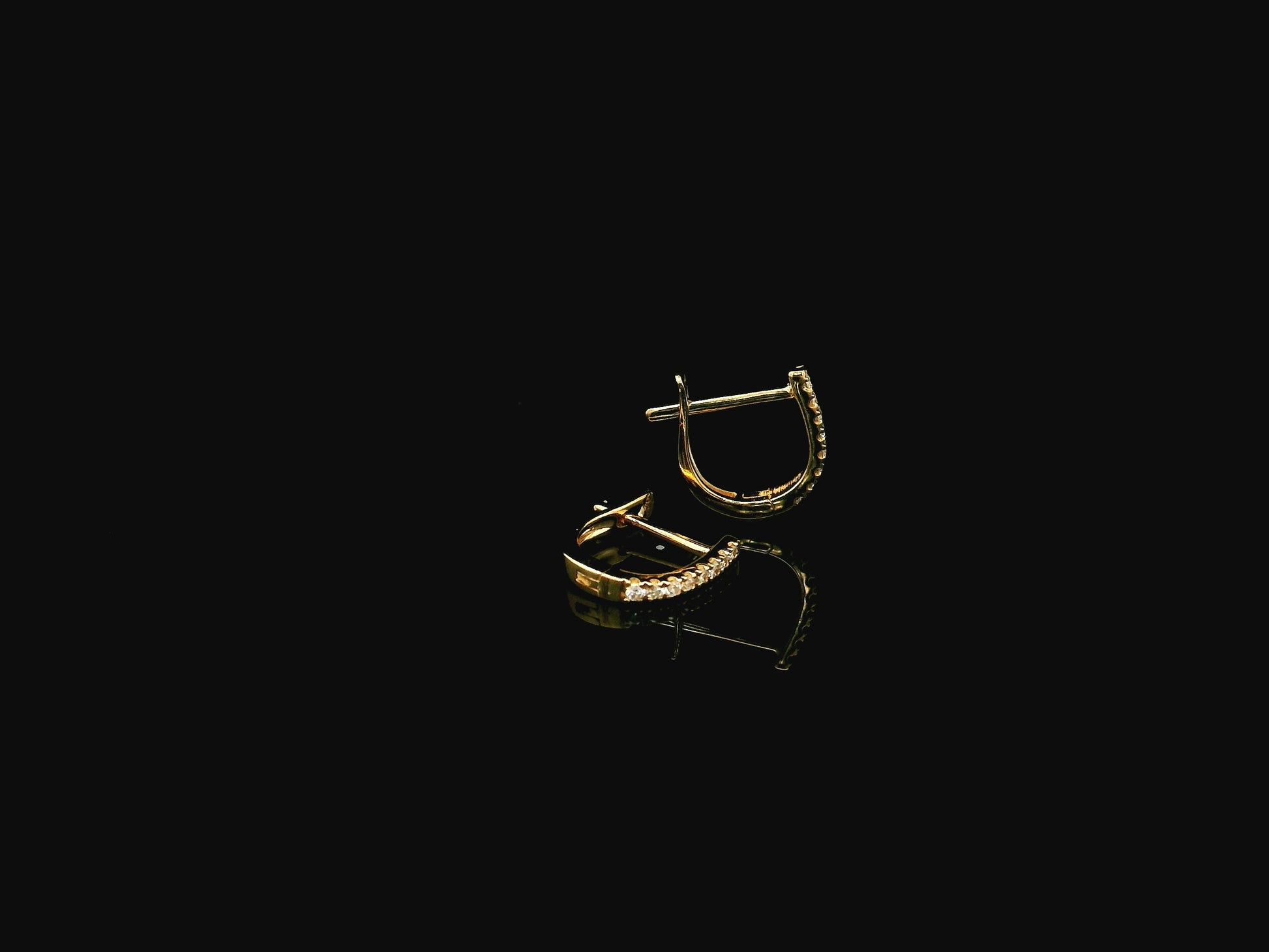 18K yellow gold diamond huggie hoop earrings featuring 0.09 carats of natural diamonds in a classic everyday hoop design.