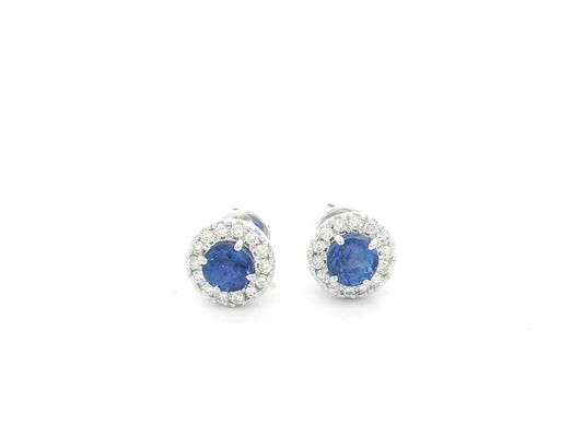 18K white gold sapphire halo stud earrings featuring 1.06 carats of blue sapphires surrounded by 0.16 carats of natural diamonds.