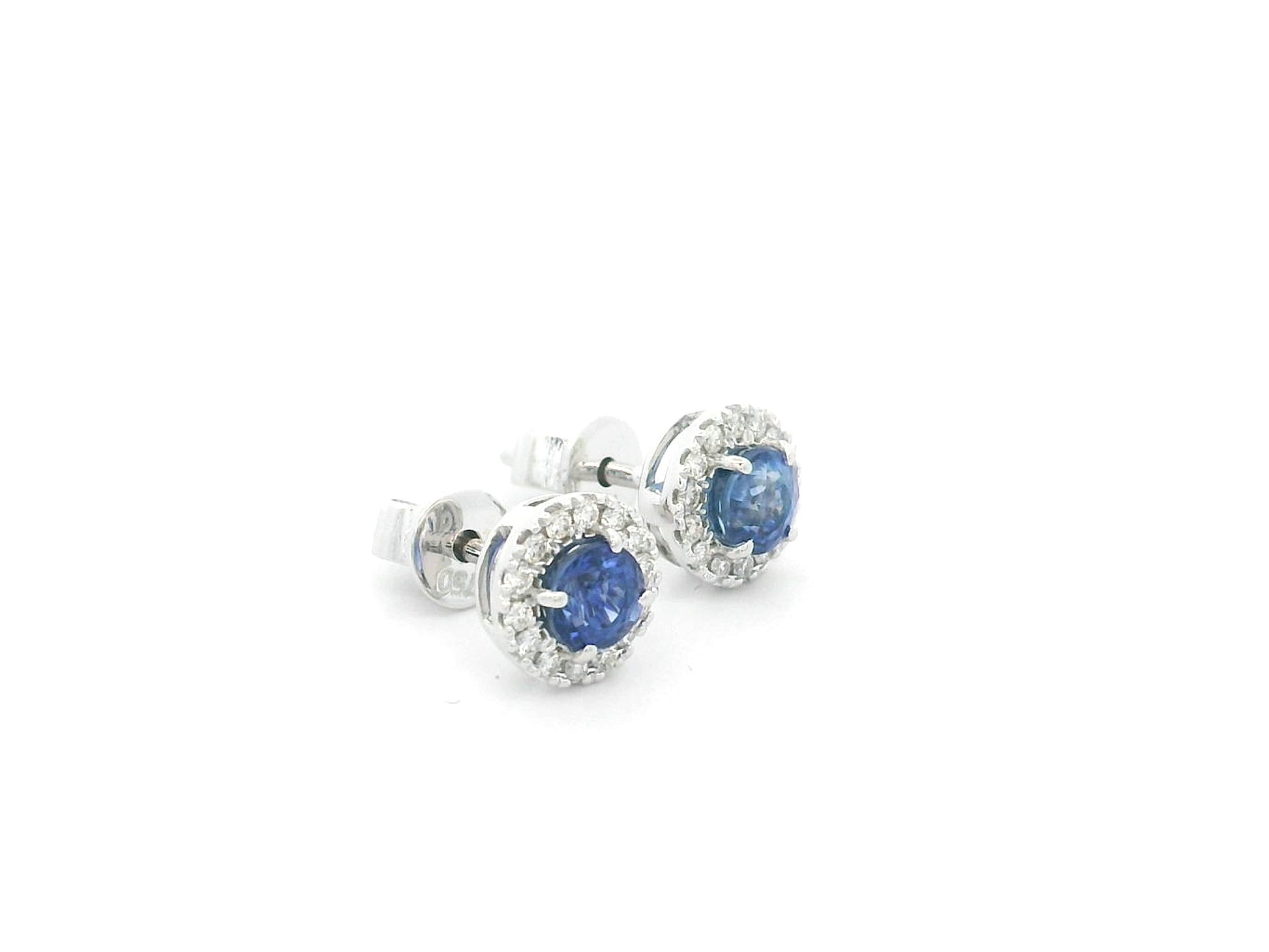 18K white gold sapphire halo stud earrings featuring 1.06 carats of blue sapphires surrounded by 0.16 carats of natural diamonds.