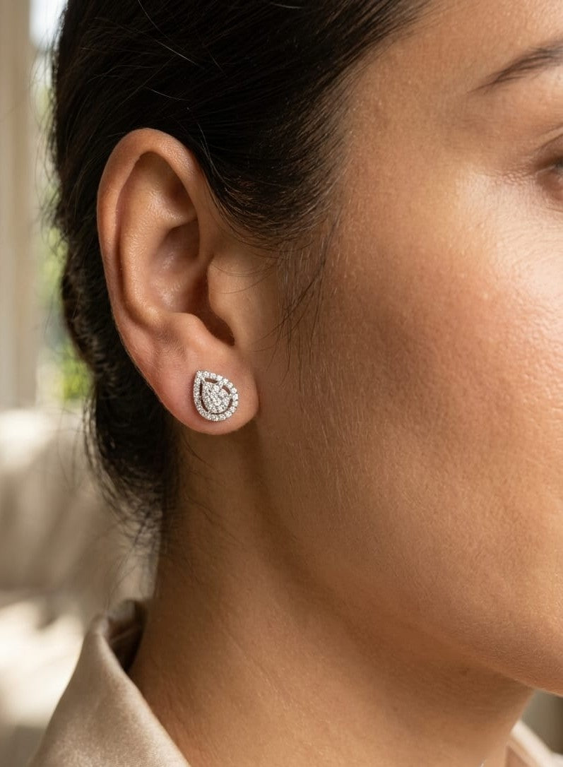 18K white gold diamond stud earrings featuring a pear-shaped cluster of natural diamonds surrounded by a sparkling diamond halo.